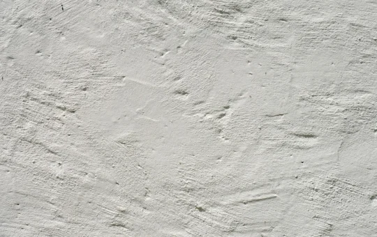 Operario alisando una pared interior con llana y pasta para eliminar el relieve del gotelé